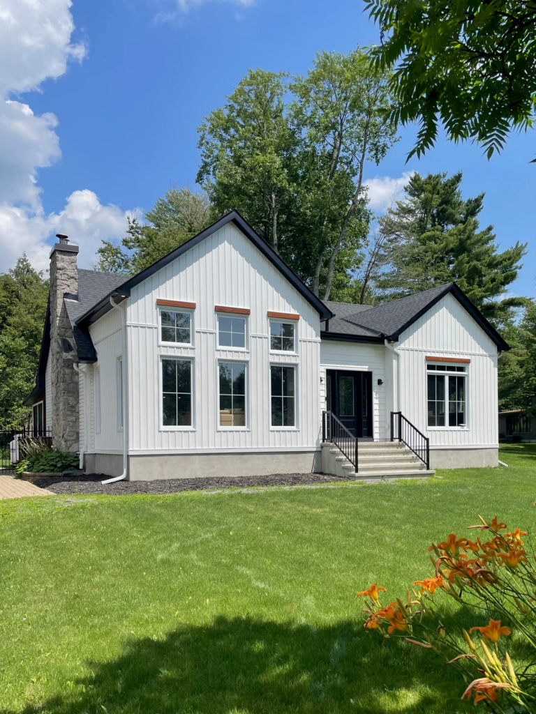 White siding home with stone chimney by Ottawa siding company Jenic Enterprises