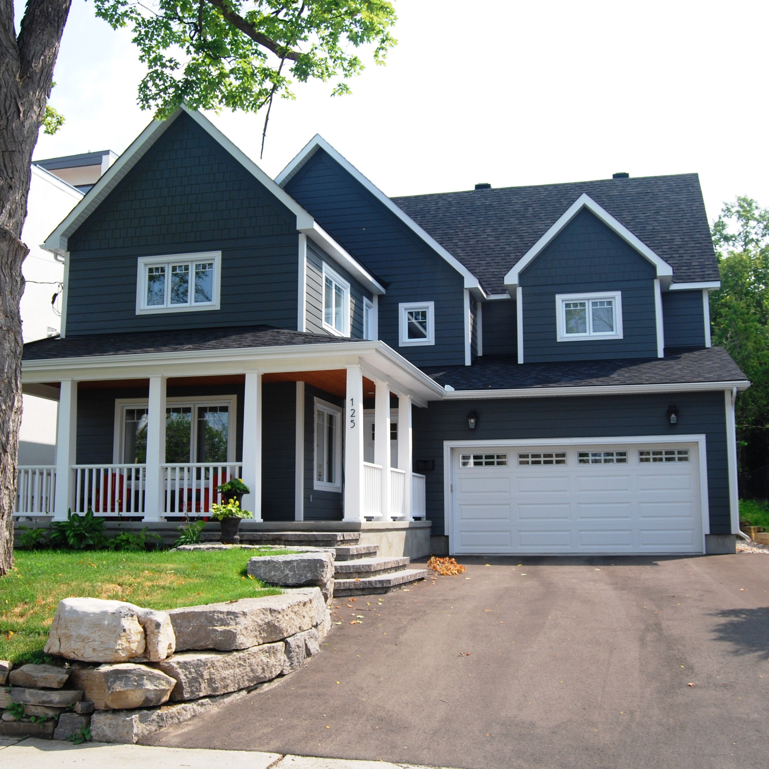 Dark grey siding Ottawa project with front porch and white garage