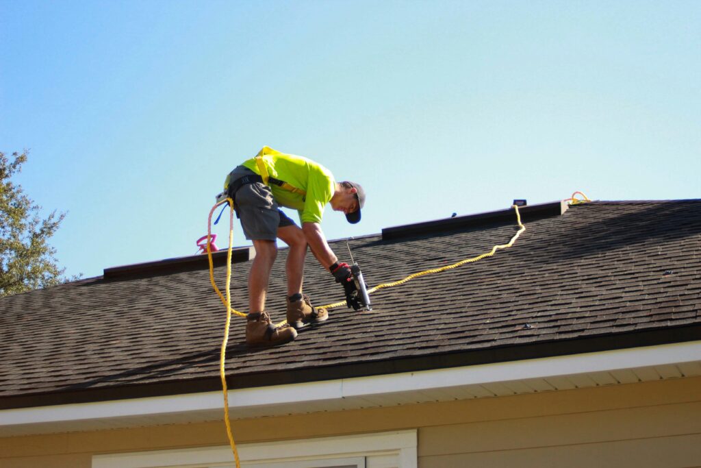 Roofing services Ottawa with contractor installing shingles on roof